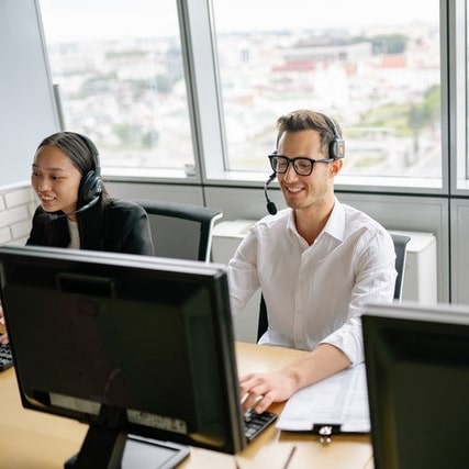 2 persons with headphone in a 2020 call center